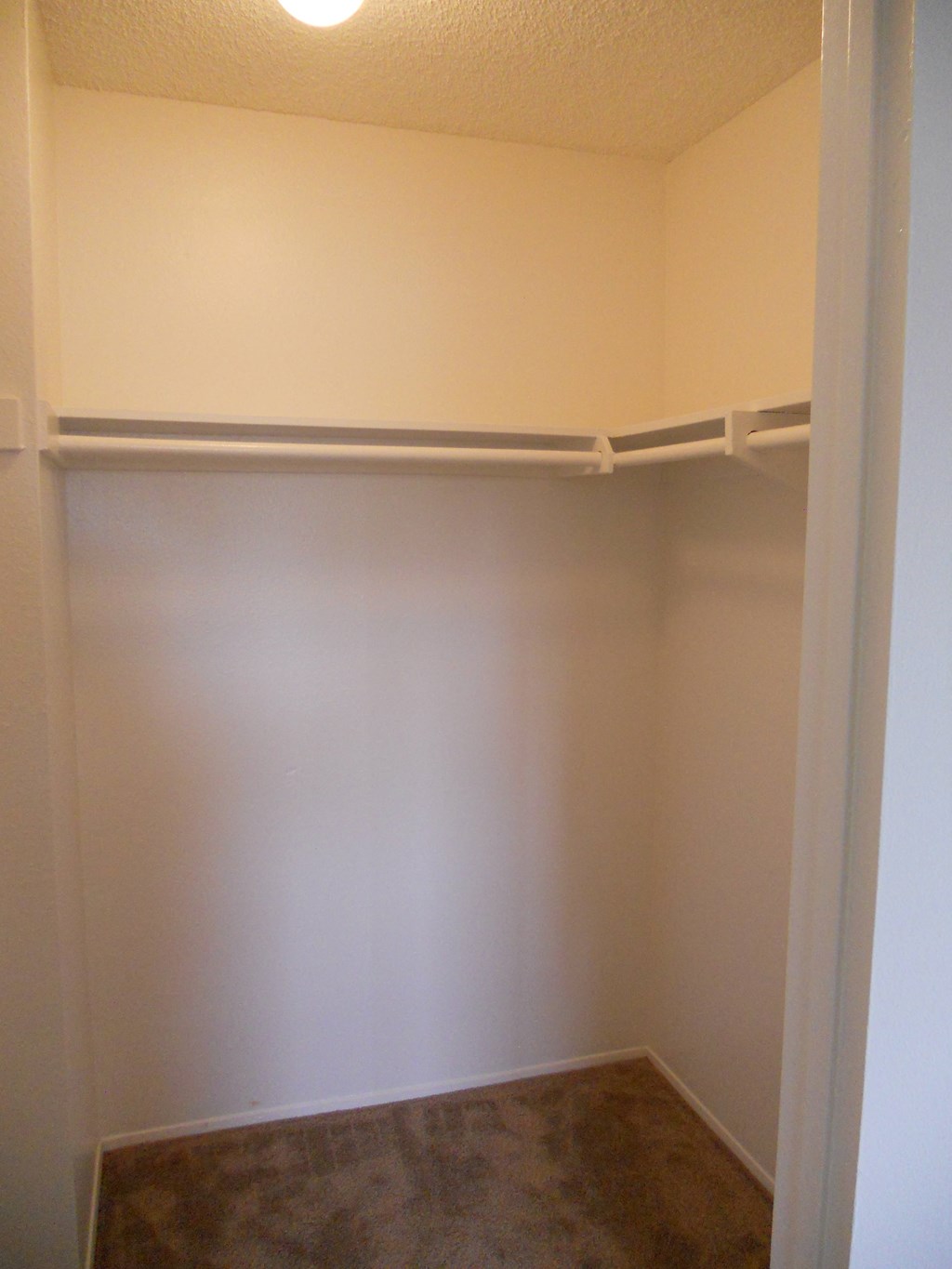 Walk-in closet in carpeted bedroom at Villa Pacific Apartments in Oceanside, California.