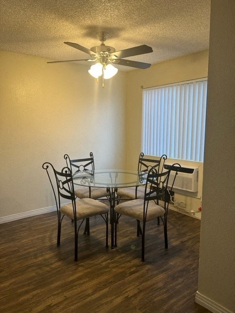 Cozy dining room area with large window and ceiling fan.