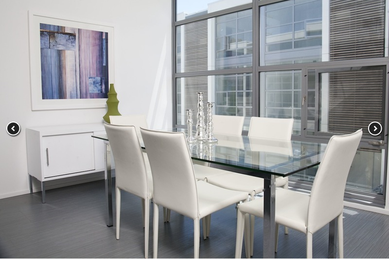 a dining room with a glass table and white chairs