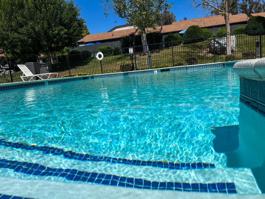 Inviting swimming pool and sun deck area with spa at Dove Ridge Apartments in Riverside, CA.