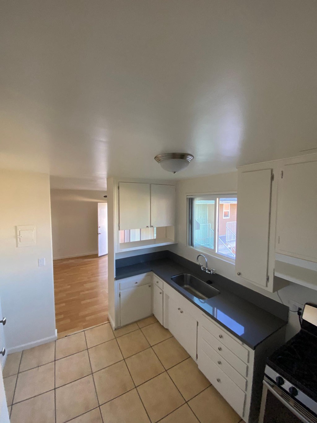 Kitchen with gas range and spacious white cabinets at Edison Apartments in Burbank, California.