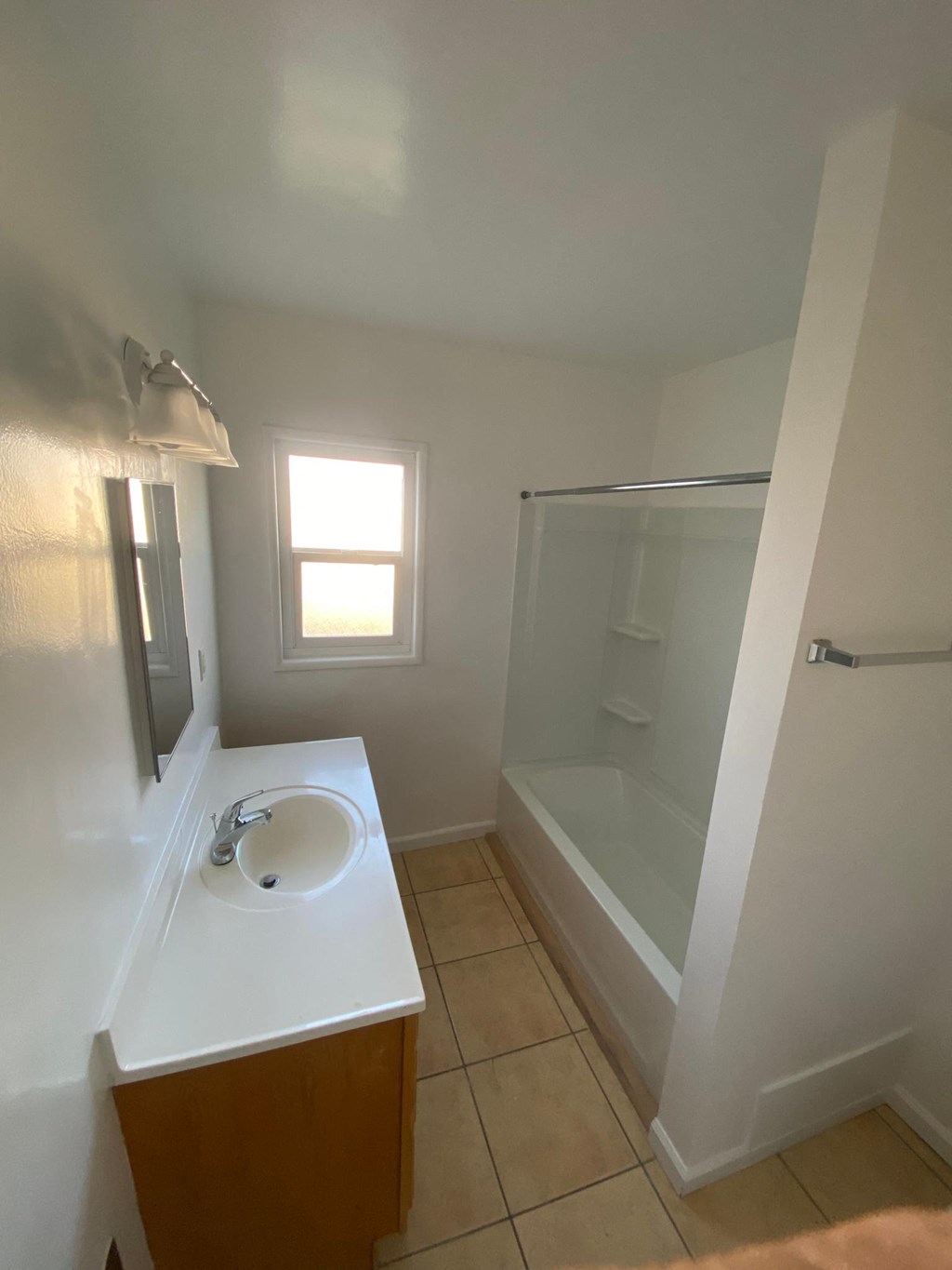 Bathroom sink and shower with natural lighting at Edison Apartments in Burbank, California.