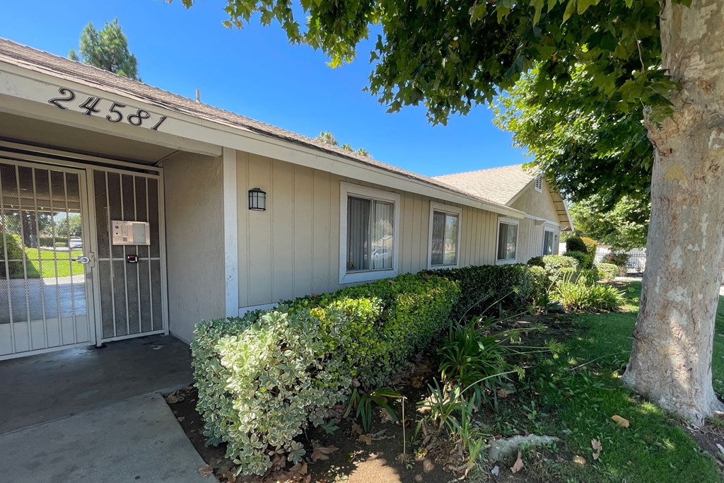 Mature trees and gardens near front entrance to Eucalyptus Apartments in Moreno Valley, California.