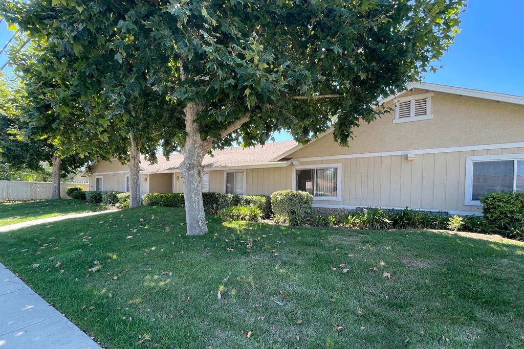 Front landscaping with marture Eucalyptus trees and well established grass at Eucalyptus Apartments in Moreno Valley, California.