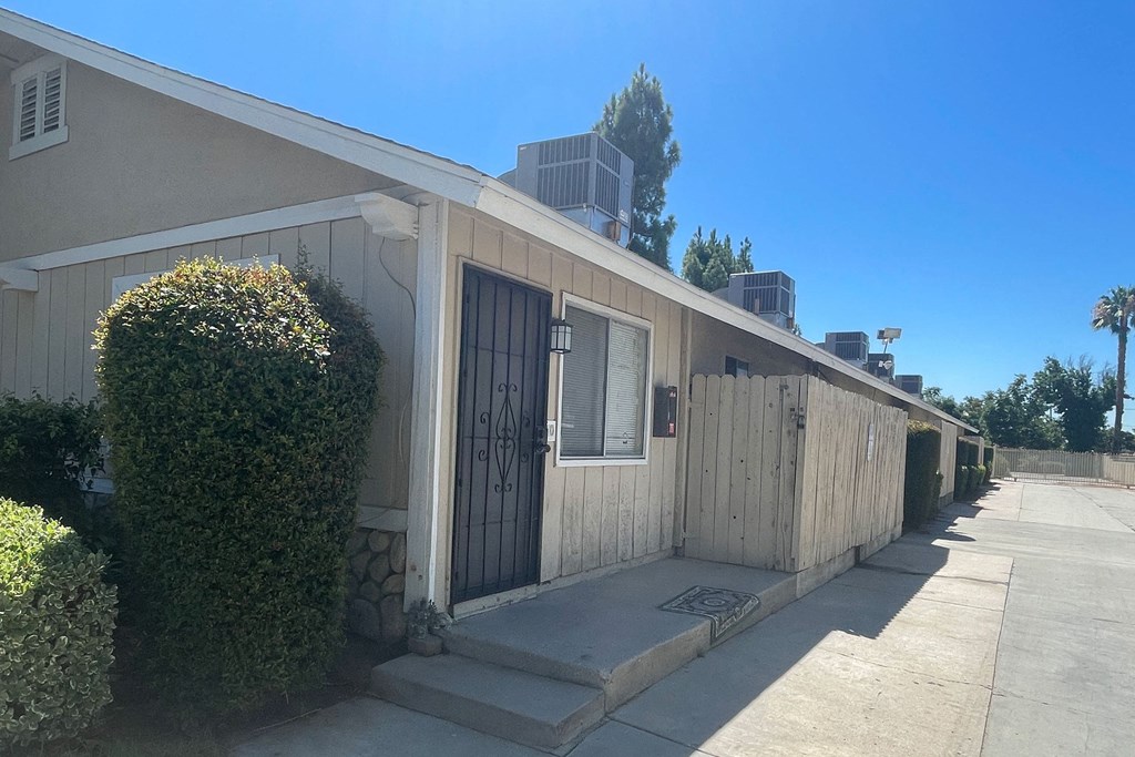 Parking lot driveway and private porches at Eucalyptus Apartments in Morneo Valley, California.
