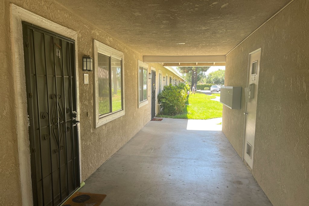 Secured entrance hallway with mailboxes and view to courtyard at Eucalyptus Apartments in Moreno Valley, California.