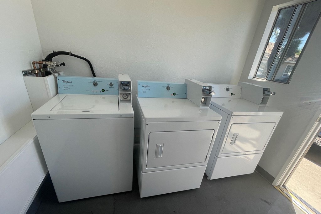 Washing machines and dryers in laundry room at Eucalyptus Apartments in Moreno Valley, California.