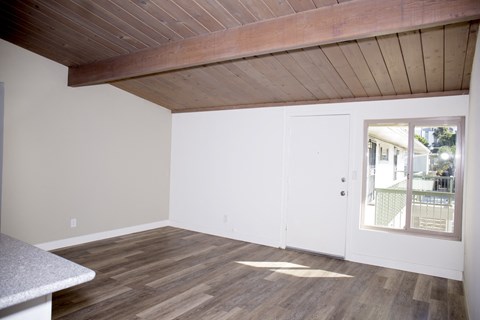 an empty living room with wood floors and a door to a patio
