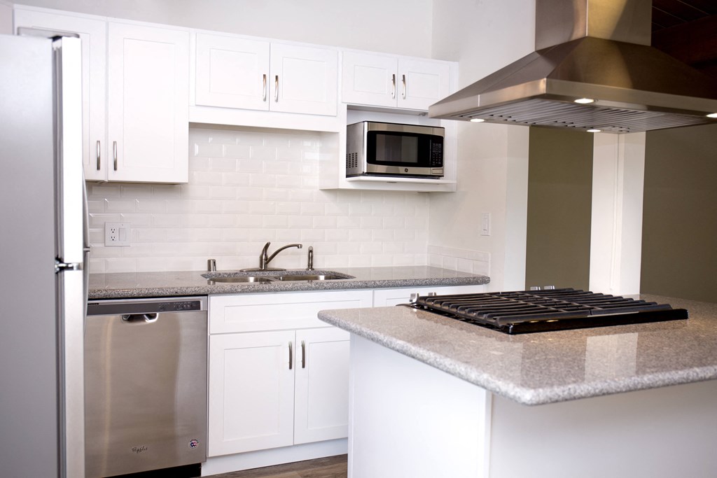 Kitchen with gas range, micorwave, and dishwasher at Harbor Villa Apartments in San Diego, California.