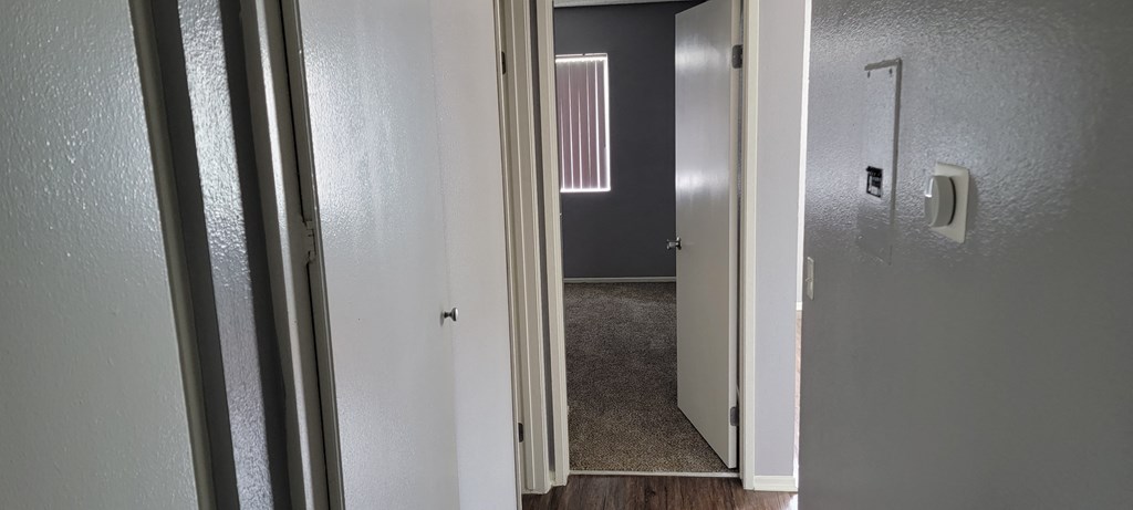 Bedroom with vertical blinds on large widow at Grand Oaks Apartments in Lake Elsinore, California.