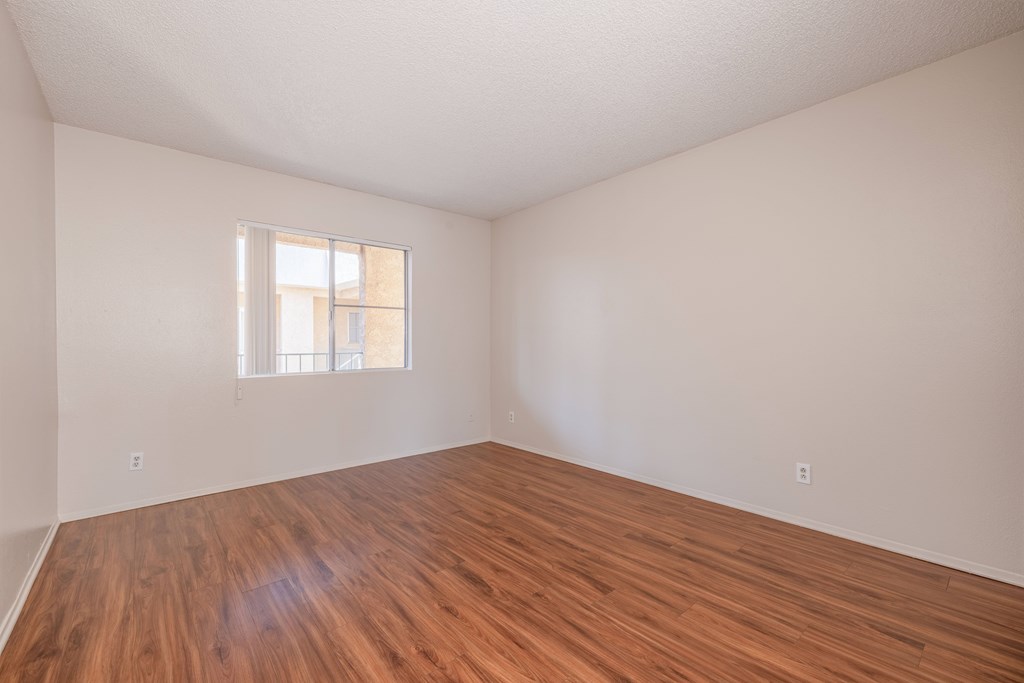 A room with wooden flooring and a window.