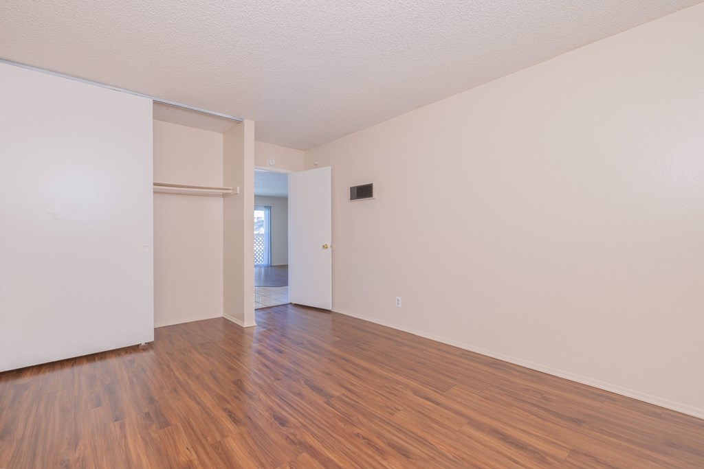Empty room with wooden floors and white walls.