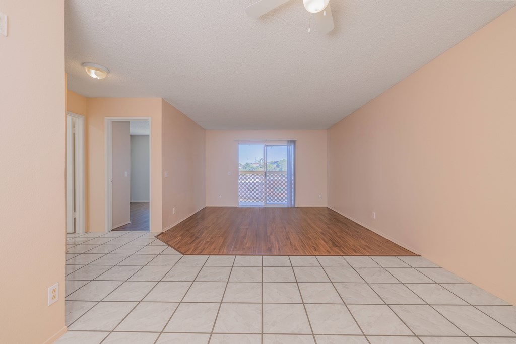 Empty room with a wooden floor and white tiled walls.
