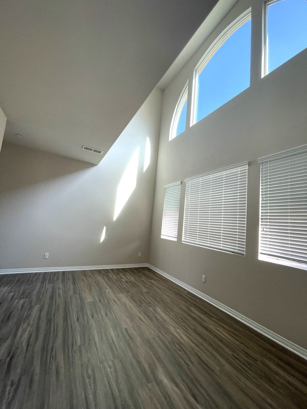 Living room with high ceilings and beautiful views in a Neptune unit at Costa Pointe in Carlsbad, California.