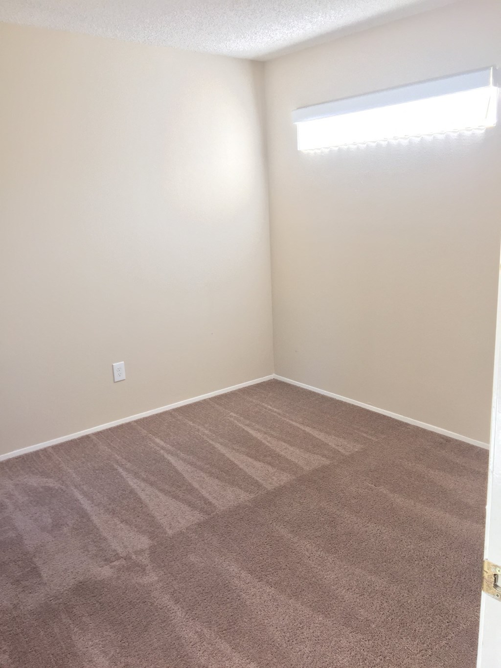 Carpeted bedroom with privacy windows at La Costa 15 Apartments.