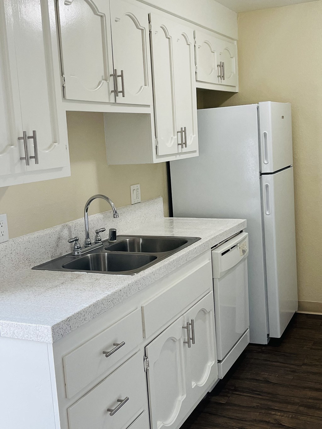 Kitchen with white cabinets and appliances at Plaza Verde Apartments in Escondido, California.