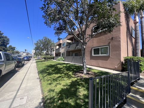 Sidewalk view of apartment buildings at Villa Pacific Apartments in Oceanside, California.