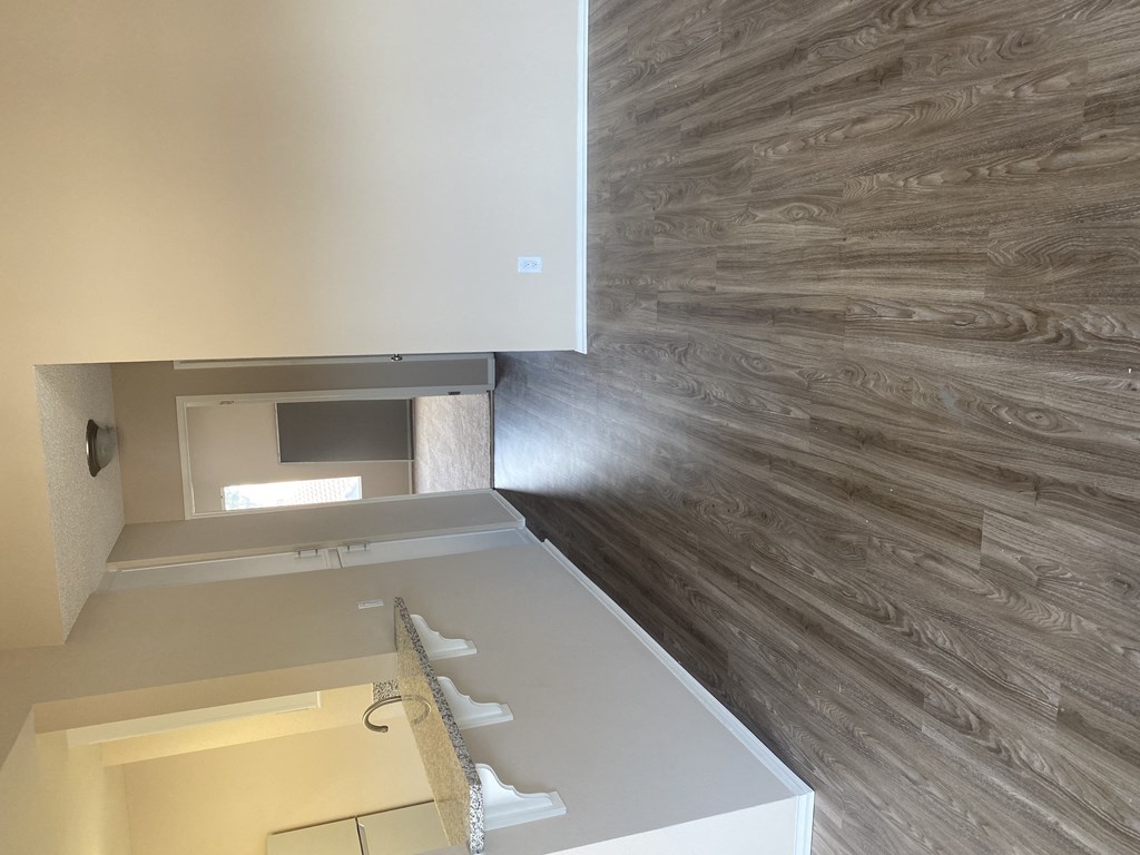 View down towards bedrooms showing living room, open kitchen and linen closet at Grande Vista Apartments.