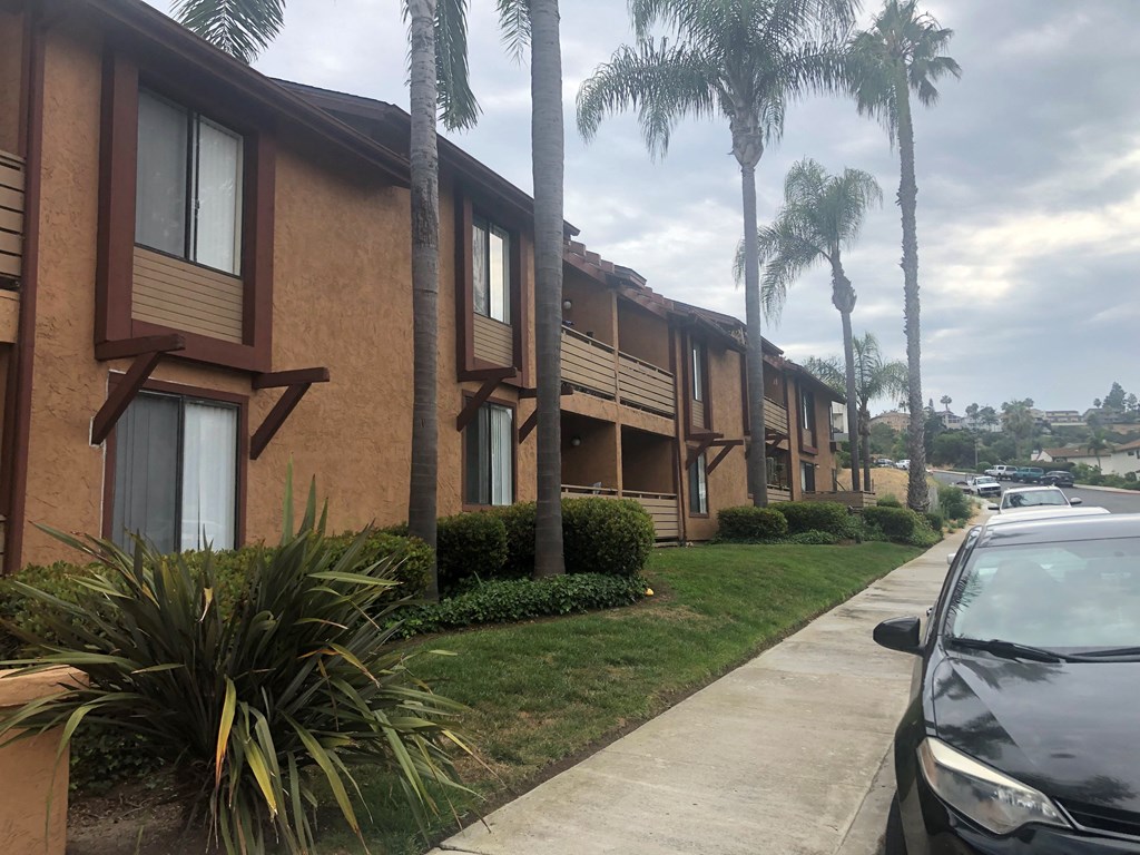 Palm trees and landscaping in front of La Costa Seashore Apartments in Carlsbad, CA.
