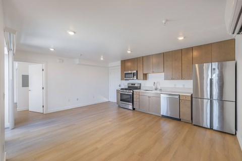 A kitchen with stainless steel appliances and wooden floors.