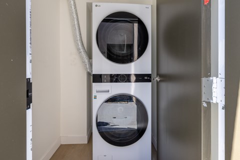 A white LG washing machine and dryer in a small laundry room.