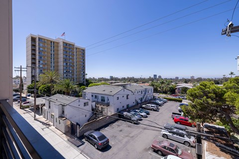 A parking lot with cars and a building with a flag on top.