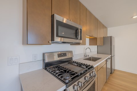 A modern kitchen with a stainless steel stove and microwave.
