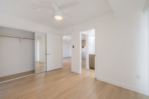 A large empty room with a wooden floor and white walls.