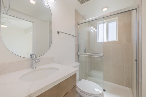 A white toilet sits next to a sink in a bathroom.