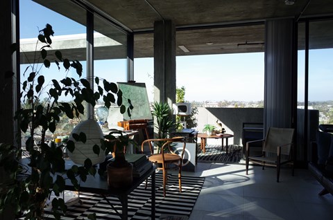 A living room with a table and chairs and a view of the outdoors.