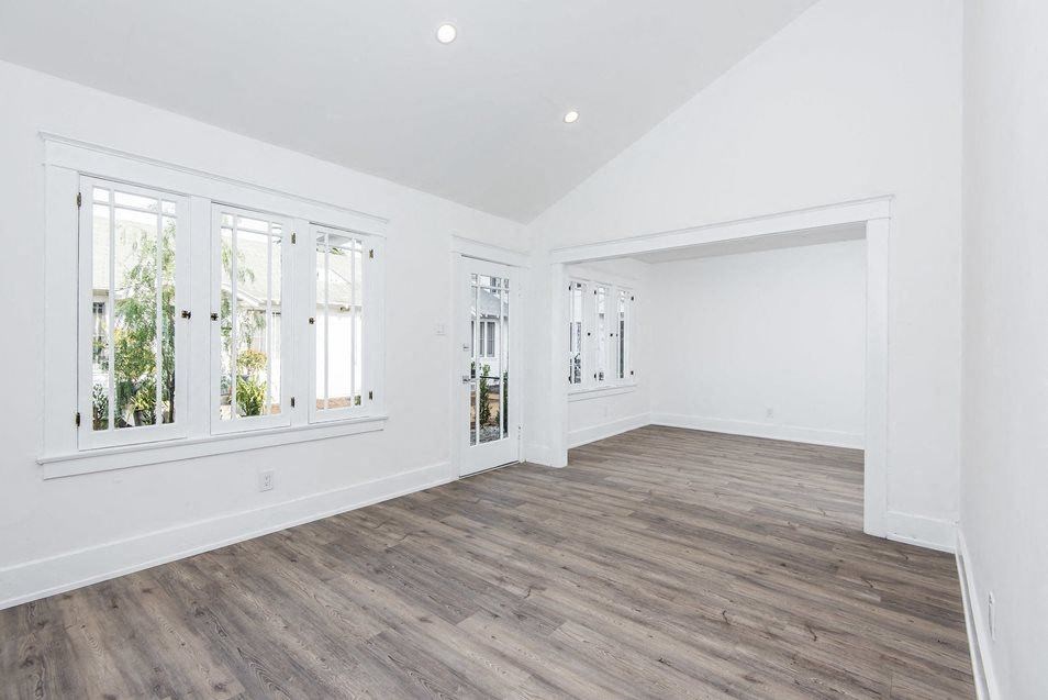 Great windows in front room and dining room with plank style flooring at 4141 Normal Avenue apartment homes in Los Angeles, California.