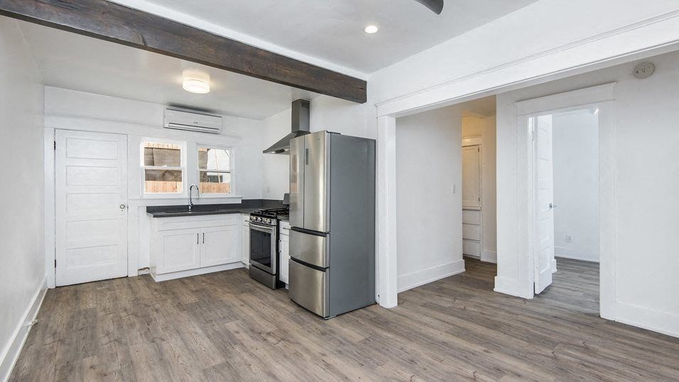Living area with view of kitchen, bedroom and hallway to bathroom at 4141 Normal Avenue apartment homes in Los Angeles, California.