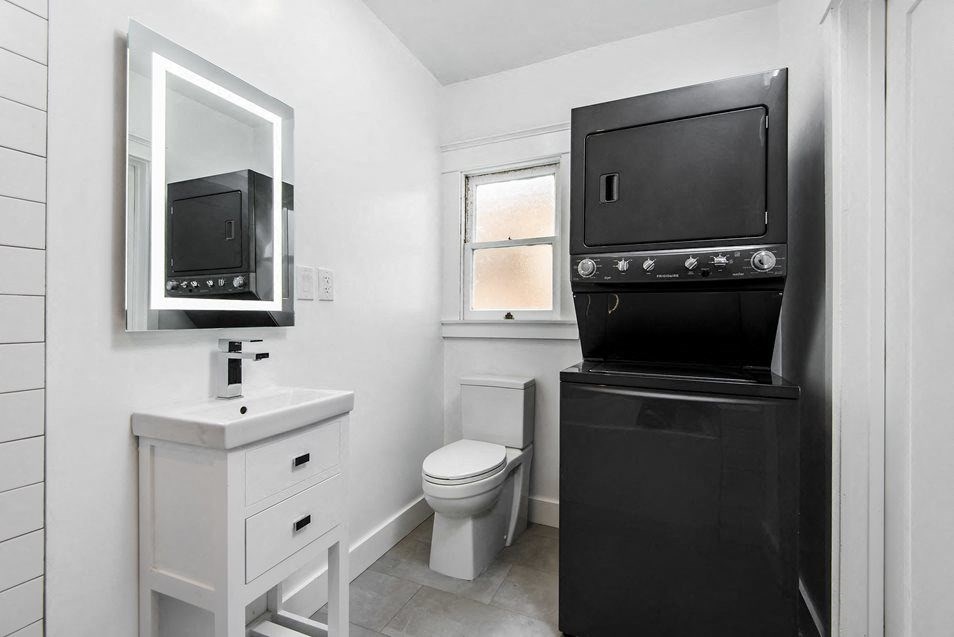 Stacked washer/dryer in bathroom at 4141 Normal Avenue apartment homes in Los Angeles, California.