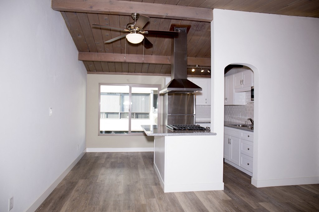 Kitchen and dining area with hardwood flooring at Harbor Villa Apartments in San Diego, California.