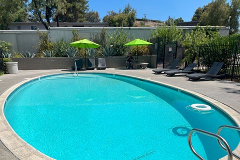 a large pool with chairs and umbrellas at a resort