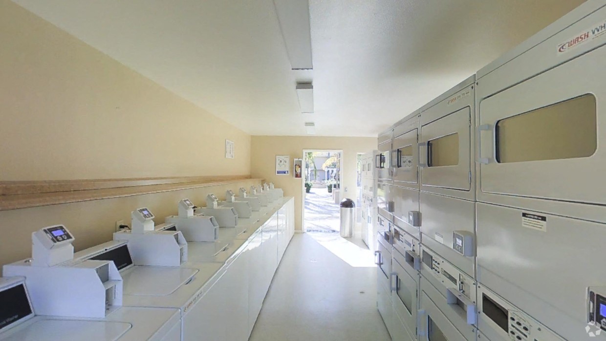 Laundry room view from back toward door with all machines in view
