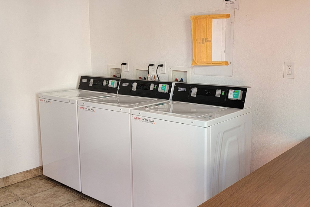 Laundry room washing machines at The Willows at Washington apartments in El Cajon, California.