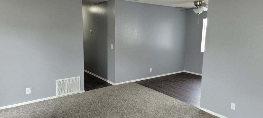 Living room view of bedroom hallway and dining room at Grand Oaks Apartments in Lake Elsinore, California.