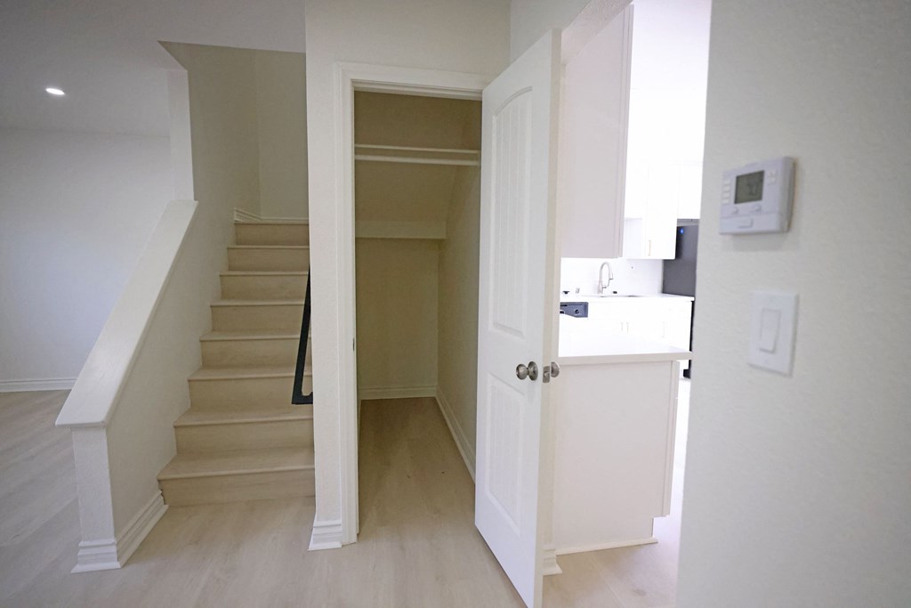 View of front room, stairs to bedrooms, spacious closet, and hallway to kitchen, bath and bonus room at Lone Pine Townhomes.