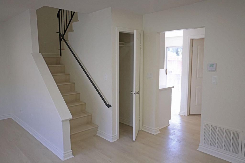 Front room view of stairs and hallway to kitchen, bathroom and bonus room at Lone Pine Townhomes in El Cajon, California.