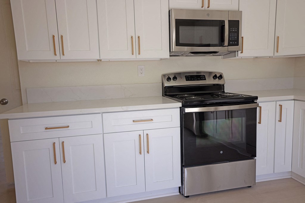 Kitchen with new electric range and microwave at Lone Pine Townhomes in El Cajon, California.