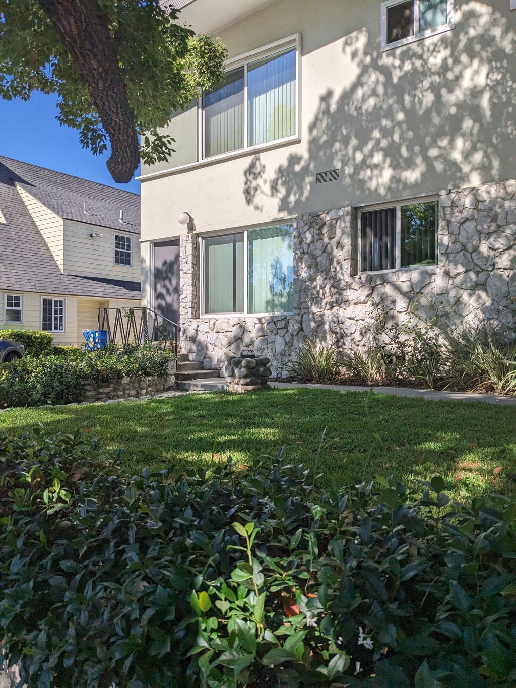 Lush gardens and shaded grass area inside gates of Los Robles Apartments in Pasadena, California.