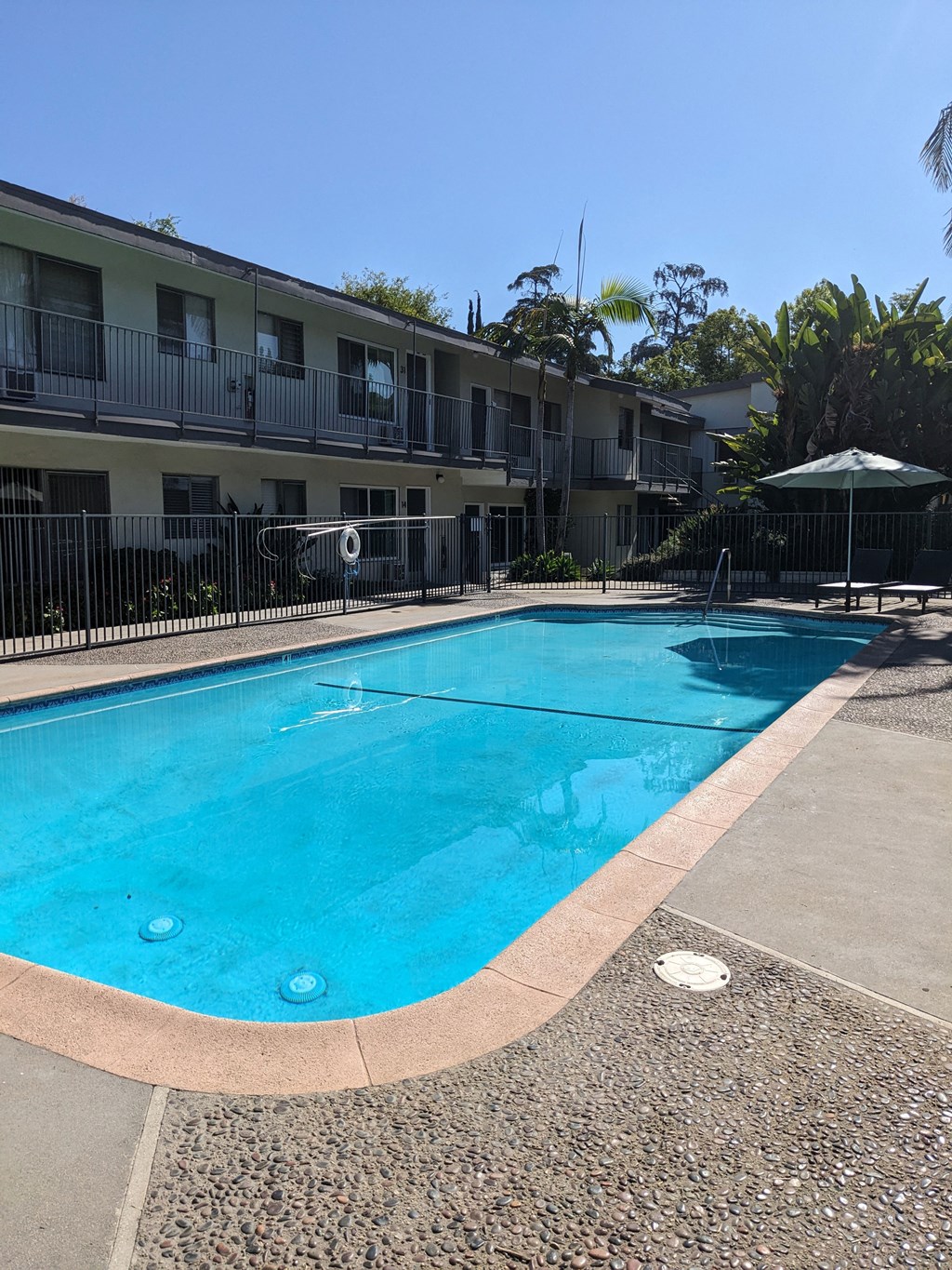 Swimming pool and apartments in gated courtyard of Los Robles Apartments in Pasadena, California.