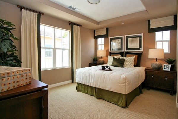 Large bedroom with lots of windows, carpeting, and a recessed ceiling at Serenata Townhomes in San Diego, California.