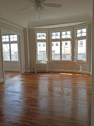 Studio apartment with hardwood floors and beautiful windows.