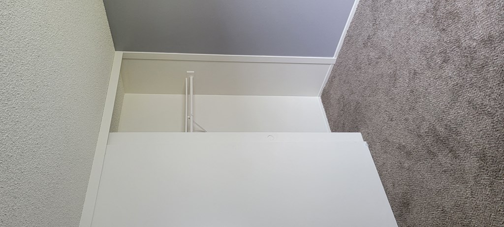 Carpeted bedroom with large closet at Grand Oaks Apartments in Lake Elsinore, California.