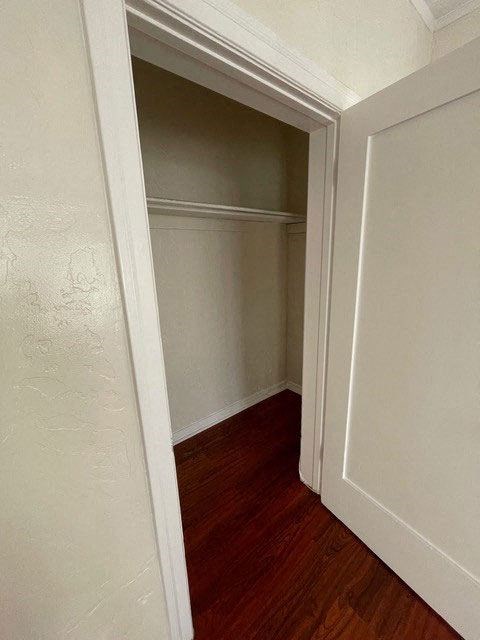 Walk-in closet and beautiful hardwood flooring in bedroom at Molino Del Mar Apartments in Pasadena, California.