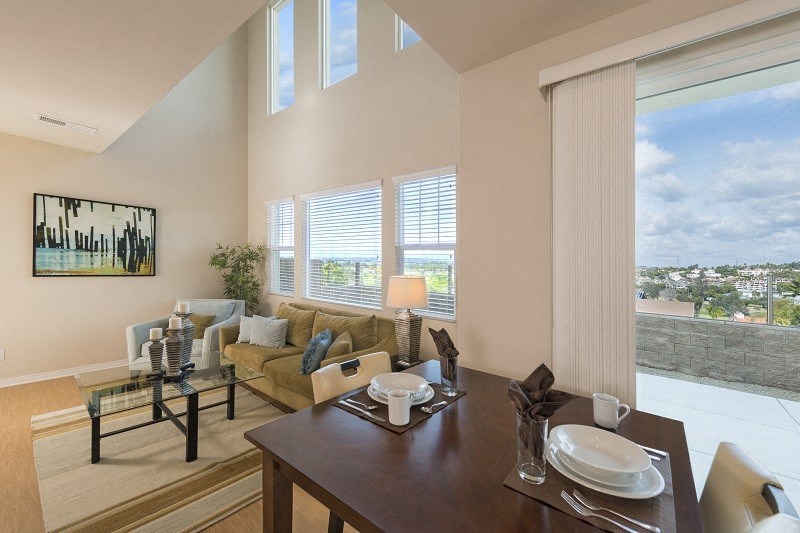 Open living room and dining room with fantastic windows and views in Neptune unit at Costa Pointe Luxury Townhomes in Carlsbad, California.