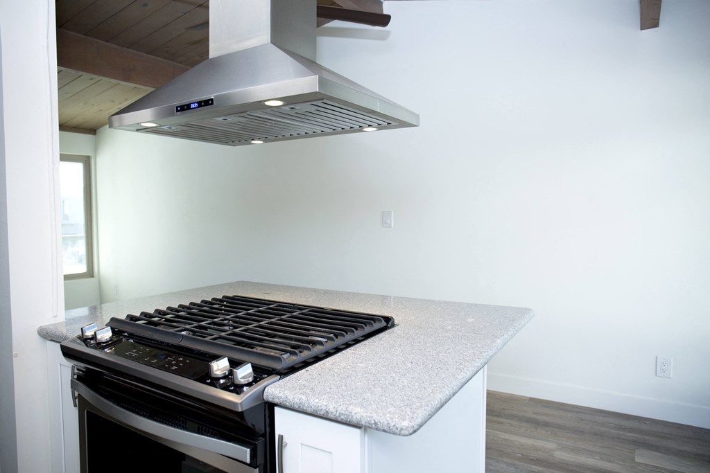 Open gas range with overhead hood at Harbor Villa Apartments in San Diego, California.