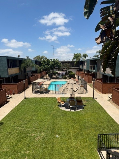 A pool surrounded by a fence and a lawn.